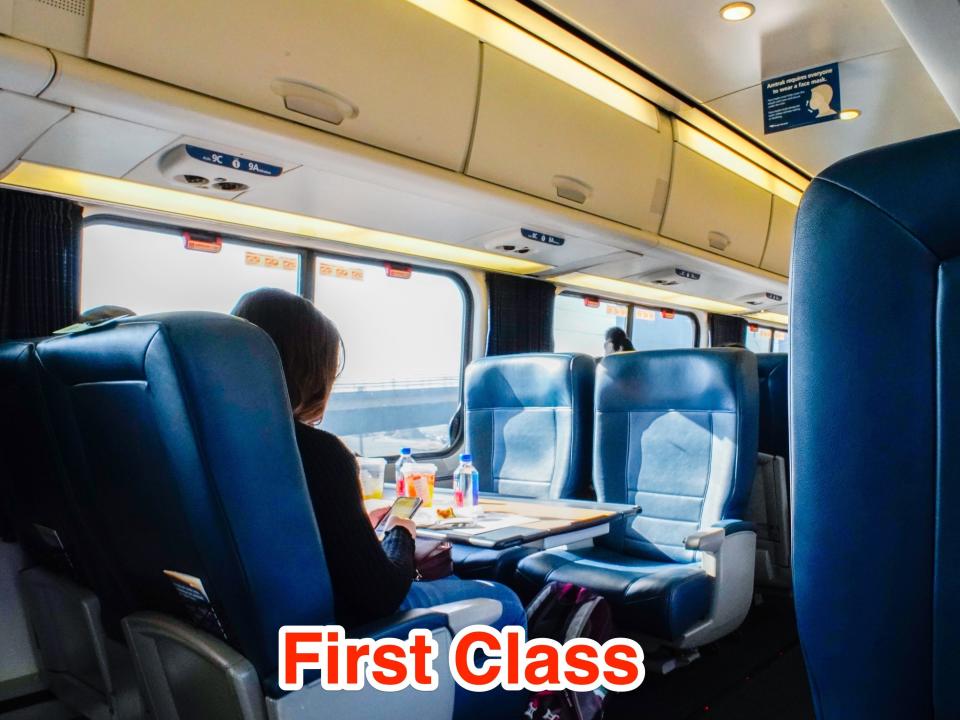 A person sits alone in an Amtrak Acela First class car