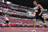 Nathan Crumpton, right, of American Samoa, competes in a heat of the men's 100-meter run at the 2020 Summer Olympics, Saturday, July 31, 2021, in Tokyo. (AP Photo/David J. Phillip)