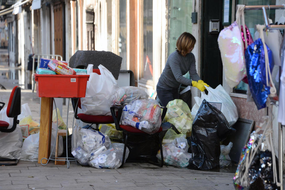 A woman cleans up following a flooding in Venice, Italy, Thursday, Nov. 14, 2019. The worst flooding in Venice in more than 50 years has prompted calls to better protect the historic city from rising sea levels as officials calculated hundreds of millions of euros in damage. The water reached 1.87 meters above sea level Tuesday, the second-highest level ever recorded in the city. (Andrea Merola/ANSA via AP)