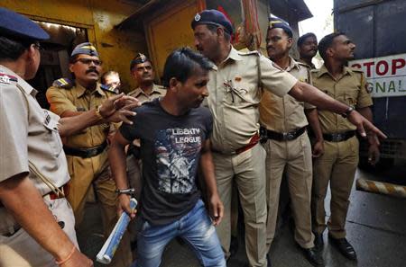 Police escort one of the four men convicted of raping a photojournalist outside a jail in Mumbai March 21, 2014. REUTERS/Mansi Thapliyal/Files