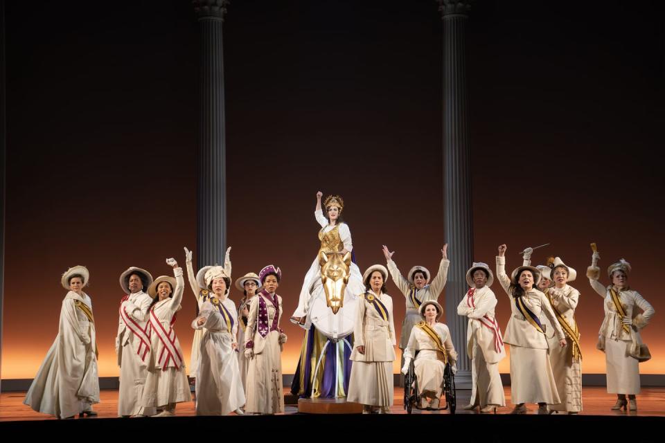 a group of people in white robes and hats on a stage