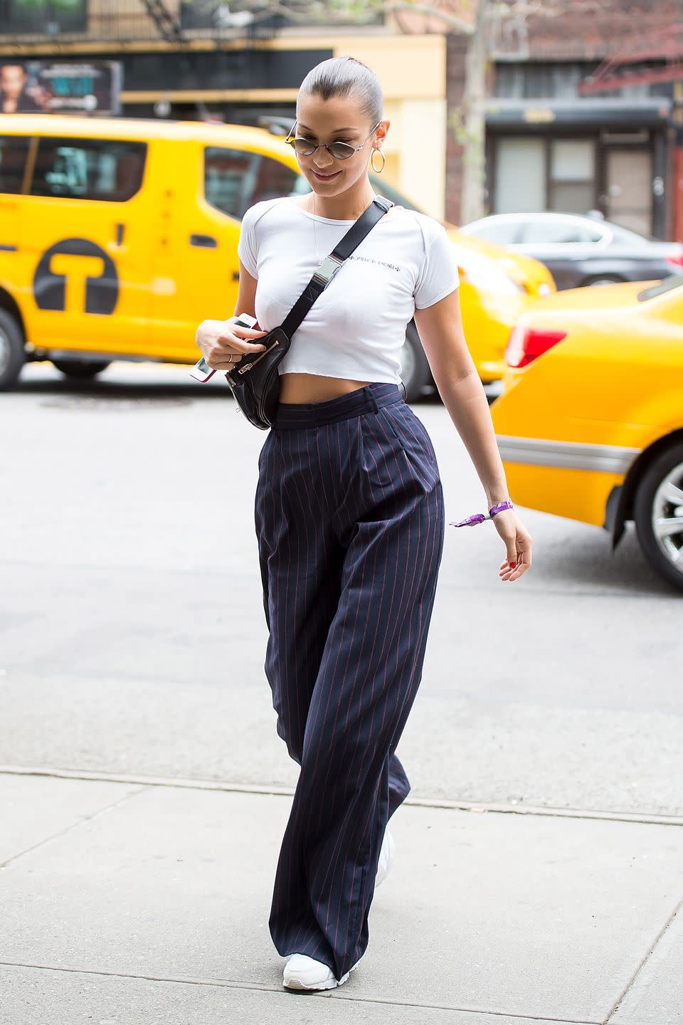<p>In loose, high-waisted pants and a white crop top in NYC. </p>