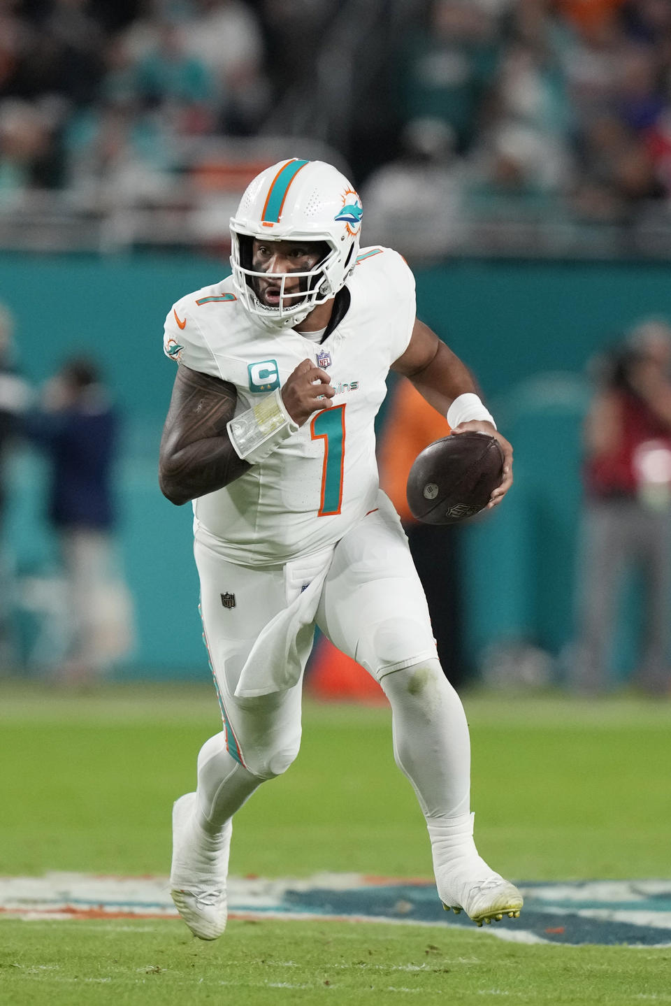 Miami Dolphins quarterback Tua Tagovailoa (1) runs with the football during the first half of an NFL football game against the Buffalo Bills, Sunday, Jan. 7, 2024, in Miami Gardens, Fla. (AP Photo/Lynne Sladky)