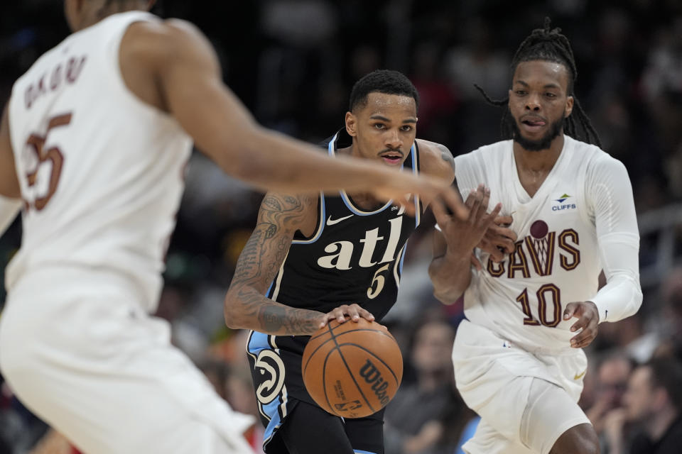 Atlanta Hawks guard Dejounte Murray (5) looks of an opening against Cleveland Cavaliers guard Darius Garland (10) during the second half of an NBA basketball game Wednesday, March 6, 2024, in Atlanta. (AP Photo/John Bazemore)