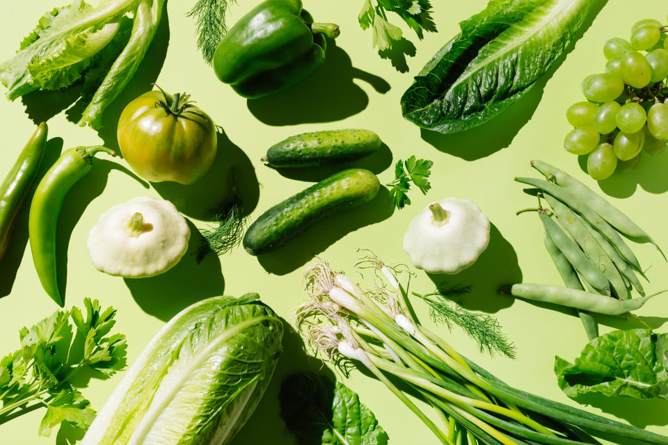 Assorted fresh vegetables and fruits arranged on a solid background, related to healthy eating