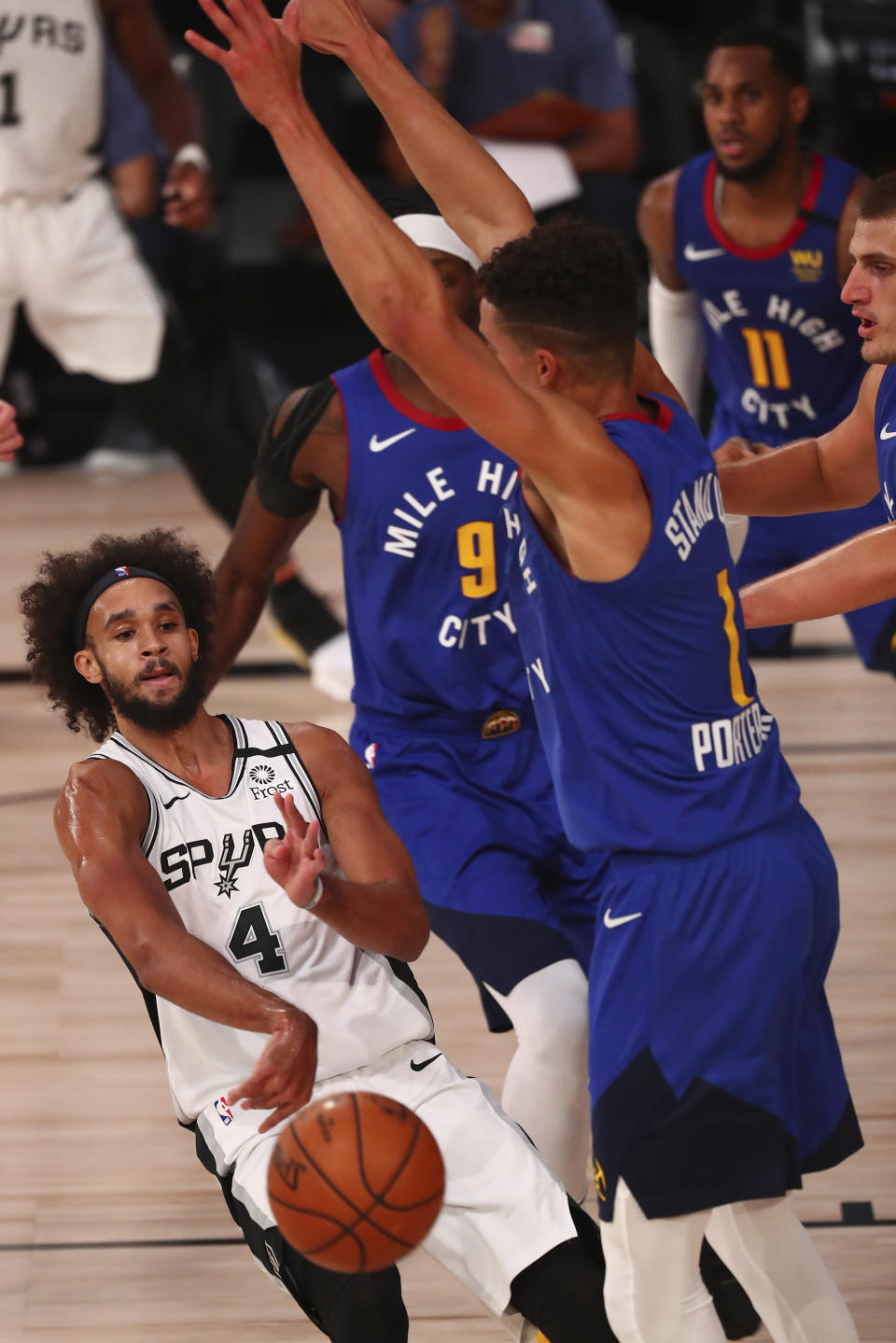 San Antonio Spurs guard Derrick White (4) passes the ball against Denver Nuggets forward Michael Porter Jr. (1) during the second half of an NBA basketball game, Wednesday, Aug. 5, 2020, in Lake Buena Vista, Fla. (Kim Klement/Pool Photo via AP)