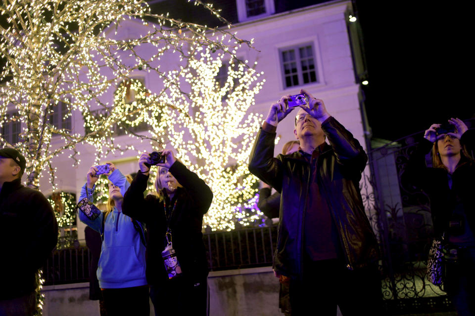 This Dec. 4, 2012 photo shows tourists photographing holiday displays in the Brooklyn borough of New York. Each holiday season, tour operator Muia takes tourists from around the world on his “Christmas Lights & Cannoli Tour” visiting the Brooklyn neighborhoods of Dyker Heights and Bay Ridge, where locals take pride in over-the-top holiday light displays. (AP Photo/Seth Wenig)