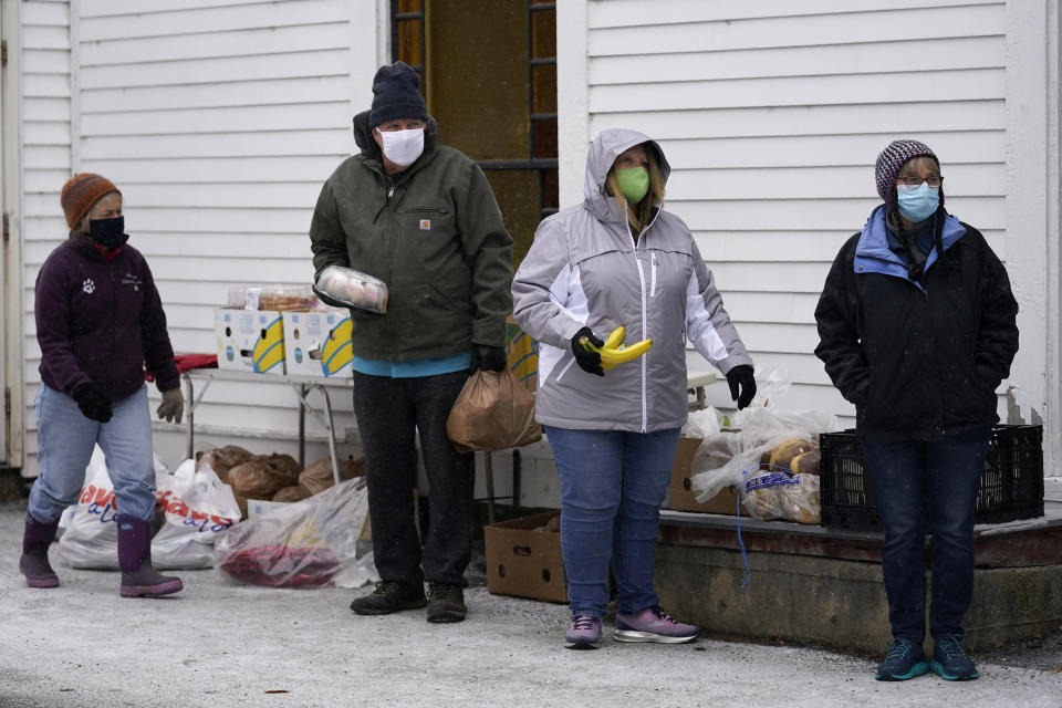 Volunteers wear face coverings to help prevent the spread of coronavirus while waiting for the next car at a drive-thru food pantry outside the First Universalist Church, Wednesday, Nov. 25, 2020, in Norway, Maine. Pictured, from left, Elishe Wilson, Steve Butler, Holly Roberts, and Sylvia Normand. (AP Photo/Robert F. Bukaty)