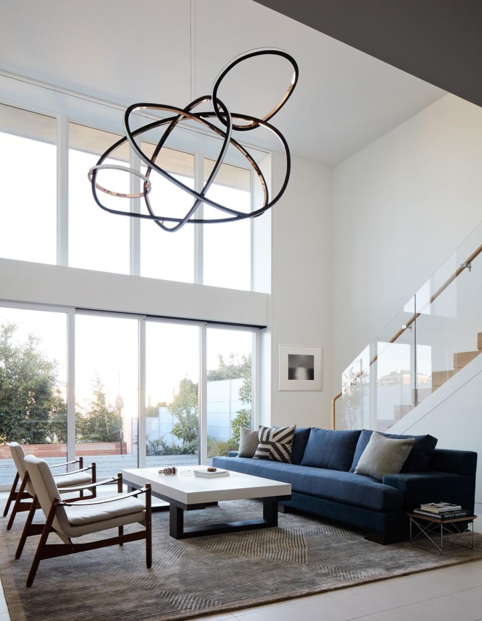 A curvaceous hanging light sculpture is the striking focal point in the lower-level family room, a casual spot for the kids to watch TV, play ping-pong, and relax. The bespoke piece, created by Irish artist Niamh Barry, was specifically designed to fit the room’s dimensions. “It really came to life in the space, and it looks so pretty from outside the house as well,” Kwong says.