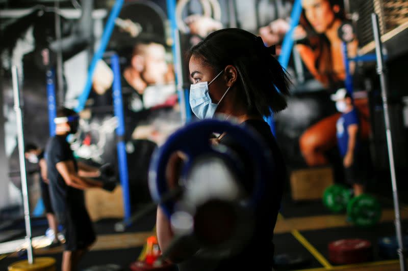 Una mujer usa una mascarilla mientras ejercita en un gimnasio en el vecindario de Ceilandia, en medio de la pandemia de COVID-19, en Brasilia