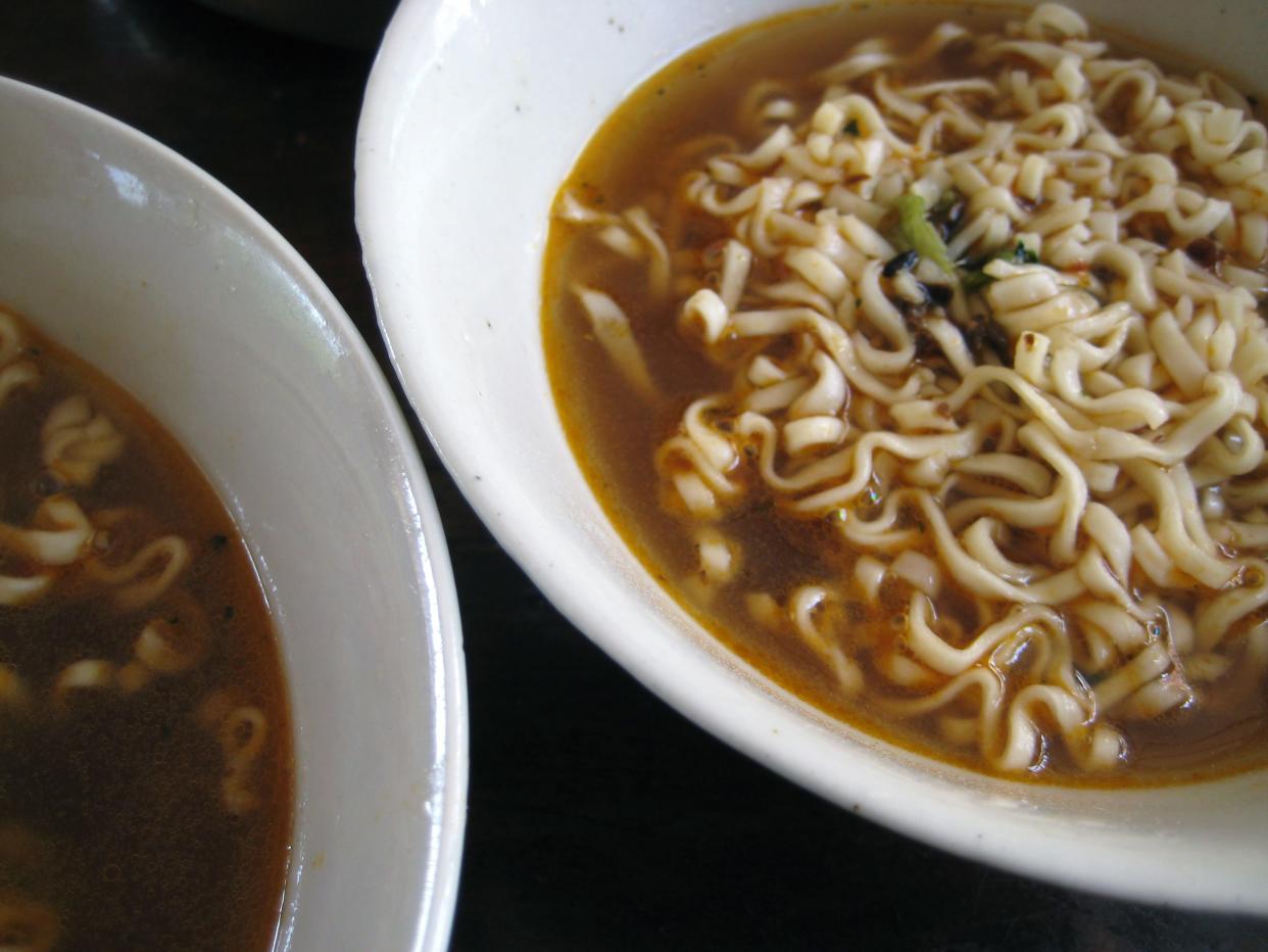 Close up of two white bowls of ramen noodles