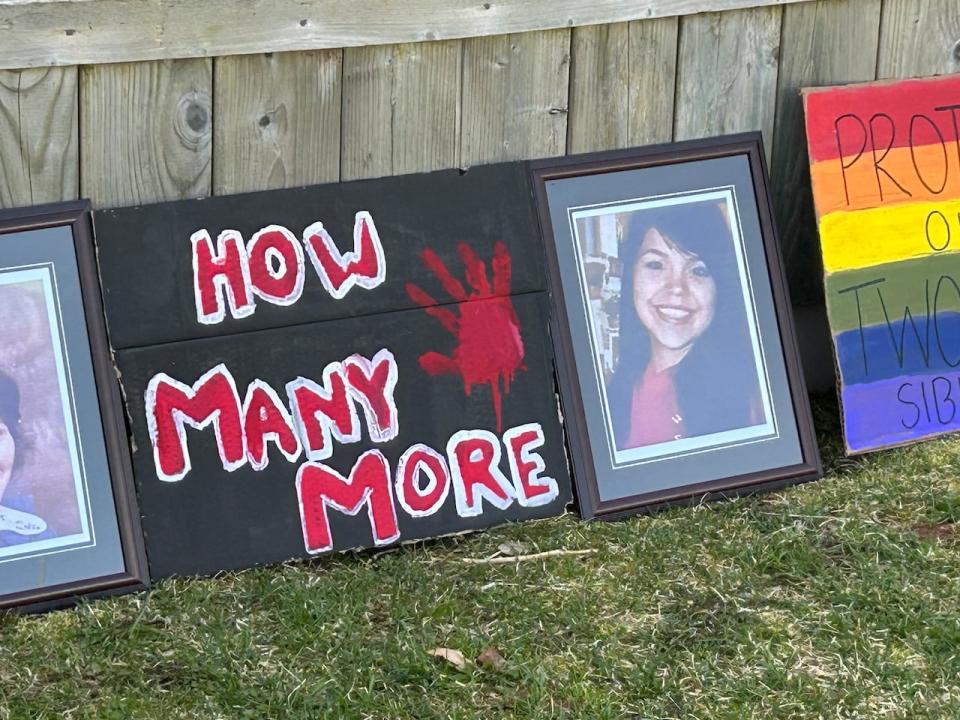 A sign with the words How Many More is placed beside a photo of an Indigenous woman.