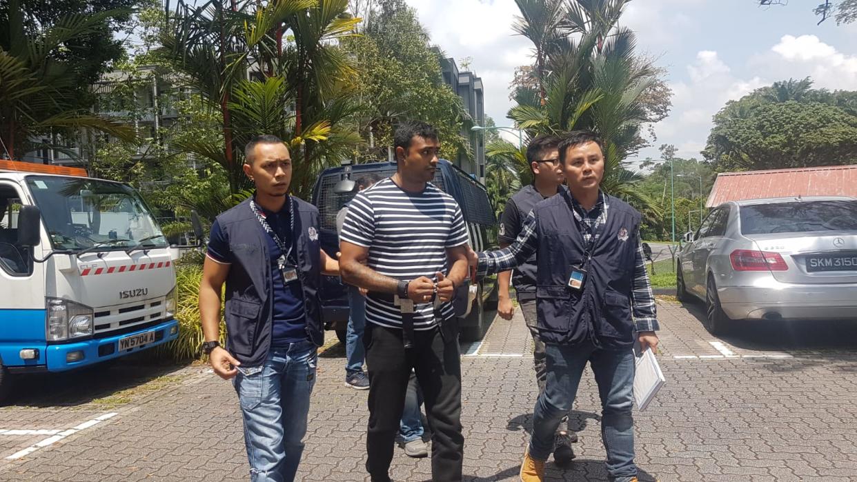 One of the suspects in the Little India slashing case is escorted by police at Lower Peirce Reservoir on Thursday, 26 July 2018. PHOTO: Wan Ting Koh/Yahoo News Singapore