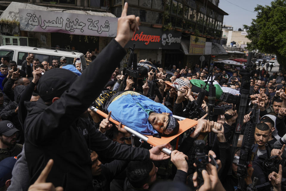 Mourners carry the bodies of three Palestinians draped in the Islamic Jihad militant group and Palestinian flags during their funeral in the Jenin refugee camp on Wednesday, March 27, 2024. The Palestinian Health Ministry said early Wednesday that three Palestinians were killed and another four were wounded by Israeli fire in Jenin. (AP Photo/Majdi Mohammed)