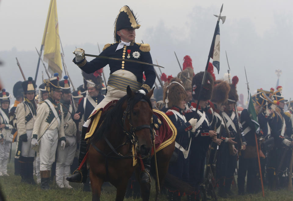 An actor playing the part of a French general, center, as other members of historic clubs wearing 1812-era uniforms perform during a staged battle re-enactment to mark the 200th anniversary of the battle of Borodino, in Borodino, about 110 km (70 miles) west of Moscow, Sunday, Sept. 2, 2012. Russia marks on Sunday the 200th anniversary of the Battle of Borodino which in 1812 was the largest and bloodiest single-day action of the French invasion of Russia. (AP Photo/Alexander Zemlianichenko)