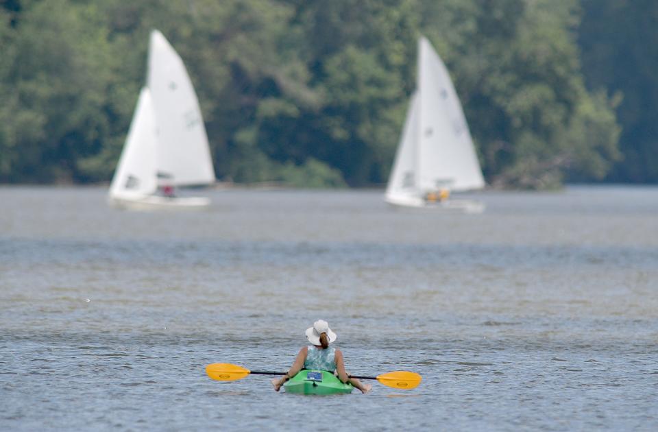 A kayaker takes a break from paddling to watch the racing action of the Interlake Sailing Class Association National’s Regatta on Thursday.