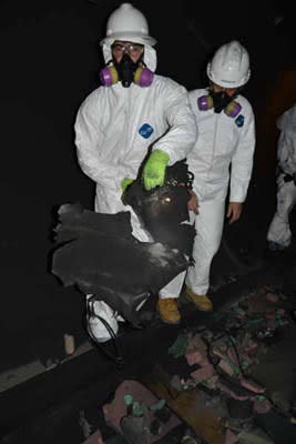 Marlon Sorge and Patti Sheaffer of The Aerospace Corporation examine the largest tank fragment from DebrisLV. The team wore gear to protect them from the dust, as well as cuts and bruises.