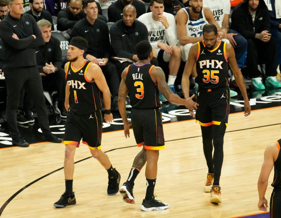 Apr 28, 2024; Phoenix, Ariz., U.S.; Phoenix Suns guard Devin Booker (1), guard Bradley Beal (3), and forward Kevin Durant (35) come together during game 4 of the Western Conference first round series against the Minnesota Timberwolves at Footprint Center on Sunday, April 28, 2024.