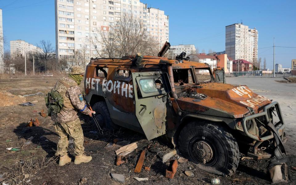 A Ukrainian soldier inspects a destroyed Russian APC after recent battle in Kharkiv - AP Photo/Efrem Lukatsky