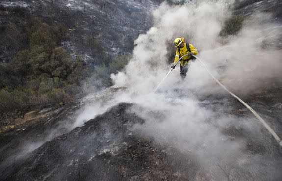 LA County firefighter Kevin Sleight extinguishes hot spots while battling the fire on Sunday, September 3, 2017.