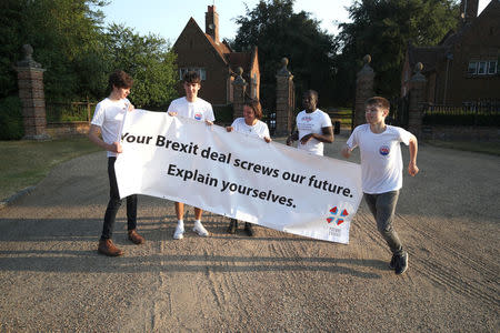 A small group of protesters, from a group called 'Our Future Our Choice', hold a banner at the gate house entrance to Chequers, the Prime Minister's official country residence, near Aylesbury, Britain, July 6, 2018. REUTERS/Chris Radburn