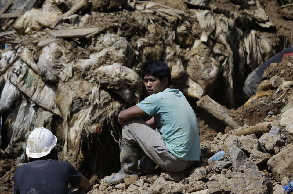 A miner waits for news as the search continues for victims believed to be buried in a landslide caused by Typhoon Mangkhut in Itogon, Benguet province, northern Philippines on Monday, Sept. 17, 2018. Itogon Mayor Victorio Palangdan said that at the height of the typhoon's onslaught Saturday afternoon, dozens of people, mostly miners and their families, rushed into an old three-story building in the village of Ucab. The building, a former mining bunkhouse that had been transformed into a chapel, was obliterated when part of a mountain slope collapsed. (AP Photo/Aaron Favila)