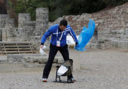 Olympics - Lighting Ceremony of the Olympic Flame Pyeongchang 2018 - Ancient Olympia, Olympia, Greece - October 24, 2017 A member of the organising staff removes plastic protecting the parabolic mirror from the rain during the Olympic flame lighting ceremony for the Pyeongchang 2018 Winter Olympics REUTERS/Alkis Konstantinidis