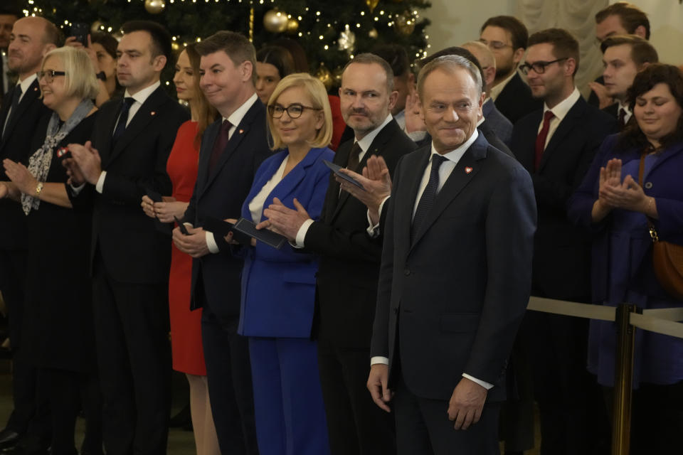 Poland's new Prime Minister Donald Tusk, right, stands next to ministers during the swearing-in ceremony at the presidential palace in Warsaw, Poland, Wednesday, Dec. 13, 2023. Donald Tusk was sworn in by the president in a ceremony where each of his ministers was also taking the oath of office. (AP Photo/Czarek Sokolowski)