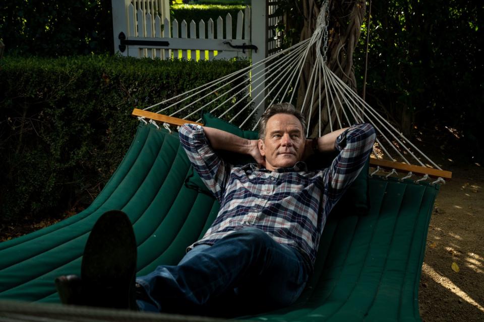 Bryan Cranston lies in a hammock in his backyard.