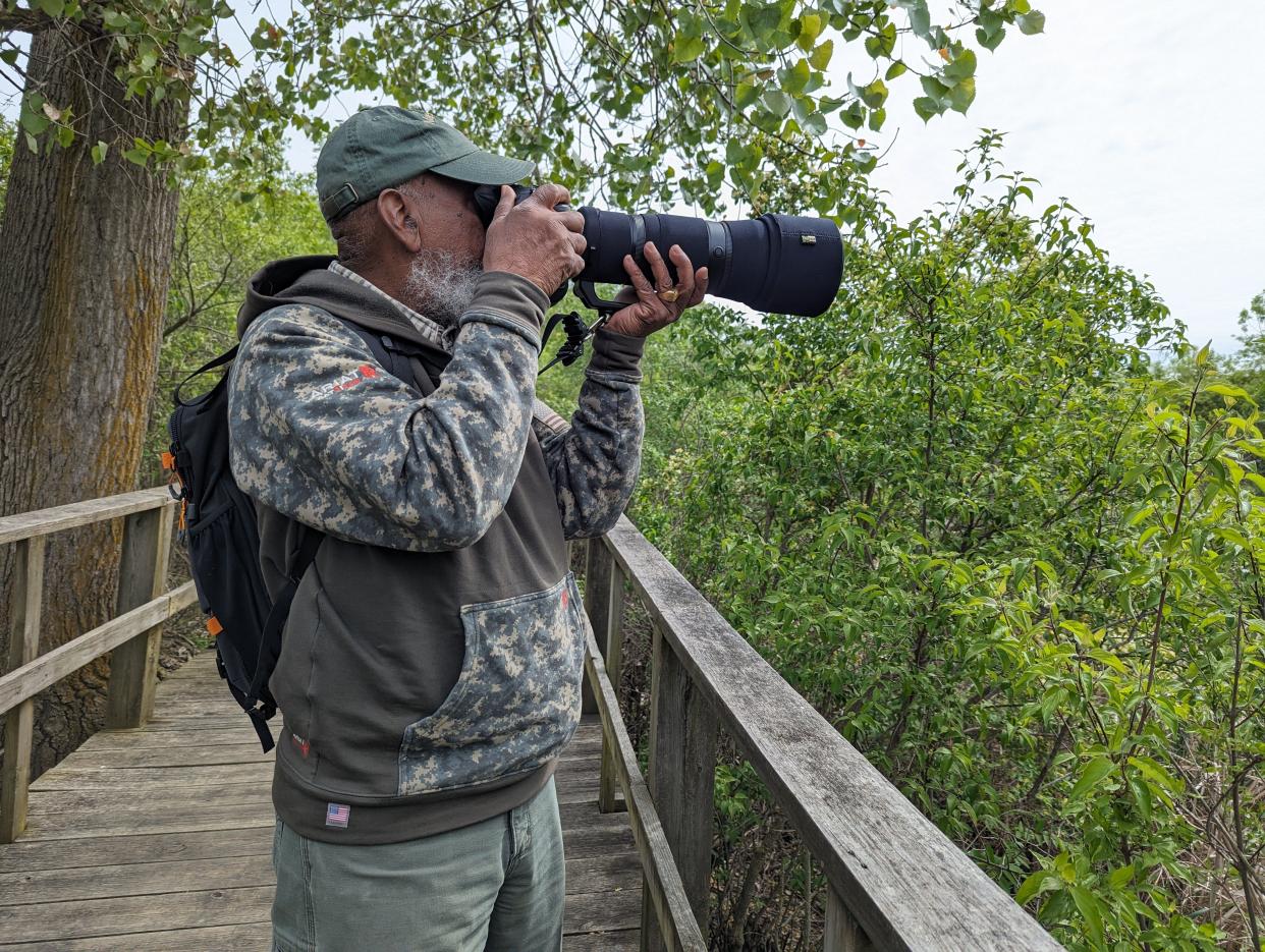 Sidney Davis, from Detroit, attempts to capture the spark in a bird's eye with his camera. He's on the boardwalk at Magee Marsh Wildlife Area during the 2024 Biggest Week of American Birding.