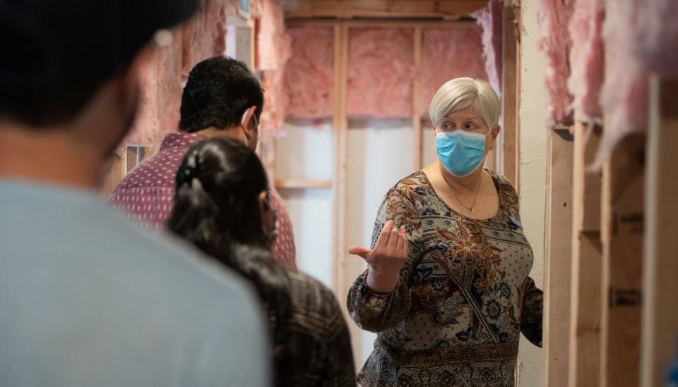 Real estate agent Leila Russell tours an unfinished basement with two interested parties during an open house in Fort Collins, Colo. on Saturday, May 8, 2021. 