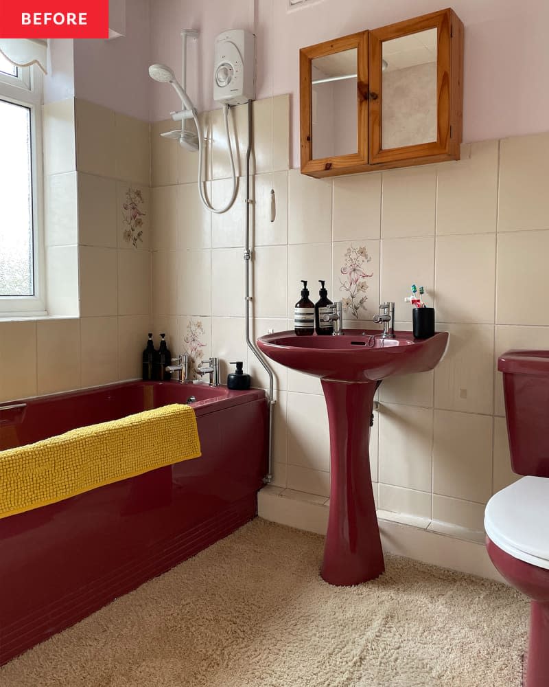 A light tiled bathroom with burgundy toilet, sink and tub.