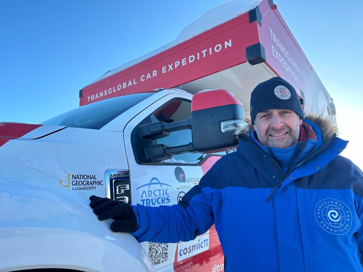 Andrew Comrie-Picard, from Edmonton, is one of the core members of the Transglobal Car Expedition. The international team is using a fleet of 12 vehicles to travel around the world using wheeled vehicles, including this modified truck that'll take them from Yellowknife to Cambridge Bay, Nunavut.  (Liny Lamberink/CBC - image credit)