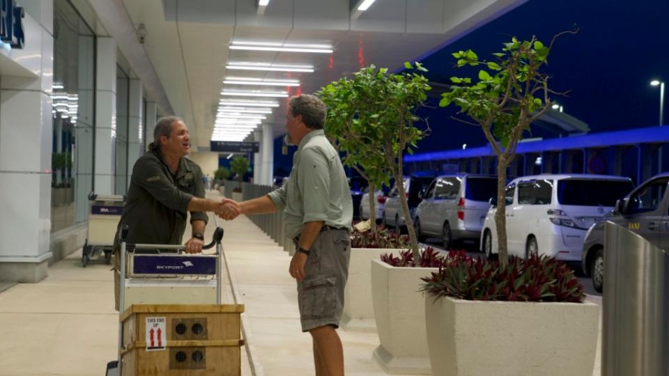 Gerardo García (izquierda) saluda al ecologista Mark Outerbridge a su llegada a las Bermudas con la caja de caracoles en peligro de extinción. (Crédito: Sandy Thin/CNN)