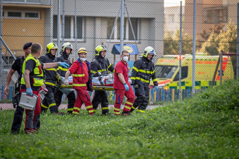 Firefighters carry a victim after a fire broke out in an apartment building in Bohumin