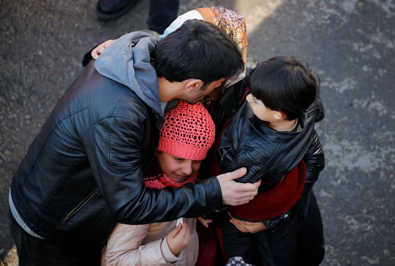 Una familia espera que los trabajadores de rescate encuentren a sus familiares entre las ruinas de un edificio derrumbado tras un terremoto en Elazig