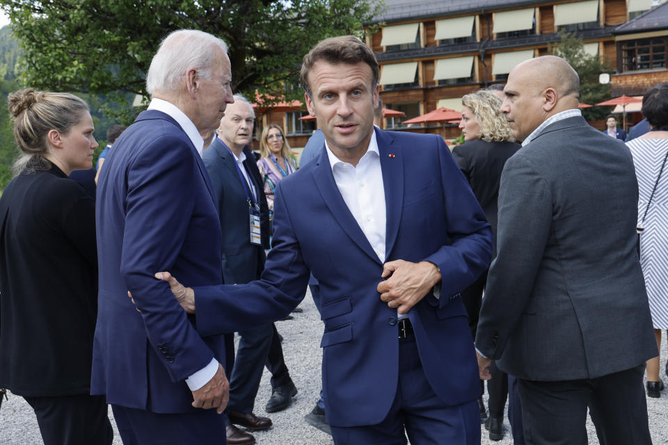 Emmanuel Macron, front right, Prime Minister of France grabs an arm of U.S. President Joe Biden, front left, as they attend a family photo opportunity at Castle Elmau in Kruen, near Garmisch-Partenkirchen, Germany, on Sunday, June 26, 2022. The Group of Seven leading economic powers are meeting in Germany for their annual gathering Sunday through Tuesday. (Jonathan Ernst/Pool Photo via AP)