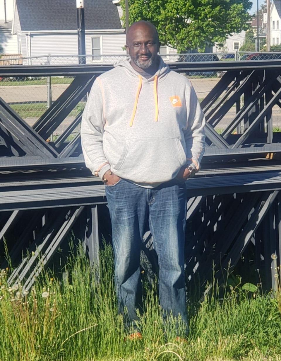 Developer Rodney Anderson stands in front of structural steel delivered to the planned All-In Grocers site in Waterloo.