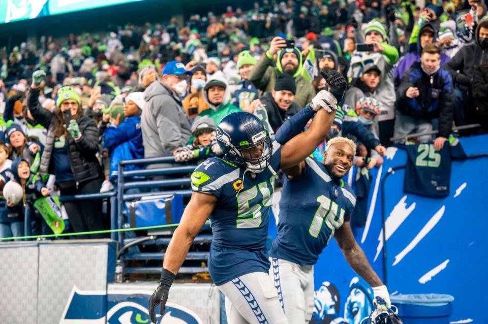 Seahawks wide receiver DK Metcalf (14) lifts up the arm of middle linebacker Bobby Wagner (54) after Wagner and the defense helped Seattle beat San Francisco 49ers, 30-23, on Sunday at Lumen Field in Seattle.