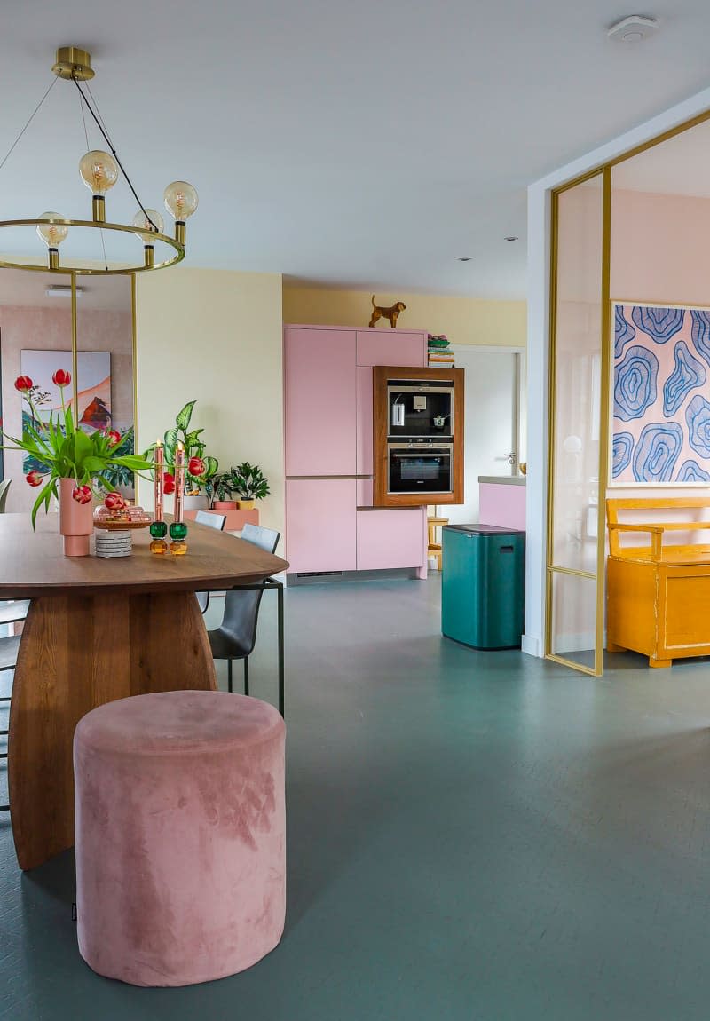 View of pastel kitchen with double oven from dining area.