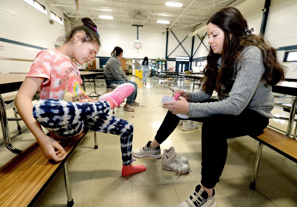 McClernand Elementary School fourth grader Jazzlynn Davis, 10, looks over one of the shoes she was trying on with of the help of third year SIU School of Medicine student Molly Smith Tuesday, Dec. 12, 2023. The medical school has provided more than 1,200 pairs of shoes to area students through the "Shoes That Fit" program since 2007.