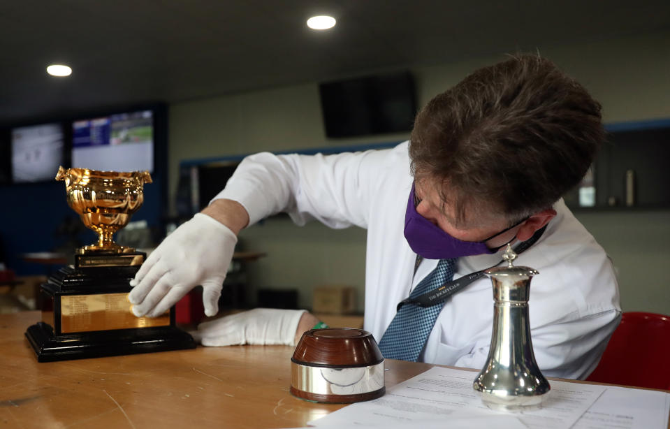 <p>Mark Morgan of Inkerman�s cleans The WellChild Cheltenham Gold Cup Chase trophy ahead of it being awarded on day four of the Cheltenham Festival at Cheltenham Racecourse. Picture date: Friday March 19, 2021.</p>
