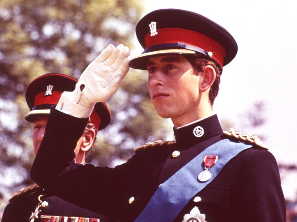 King Charles in his 20s saluting in a military uniform