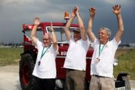 Swiss fans Josef Wyer, Beat Studer and Werner Zimmermann celebrate after driving an old-time tractor from home to Kaliningrad stadium to watch their team playing against Serbia, in Kaliningrad, Russia June 21, 2018. REUTERS/Mariana Bazo