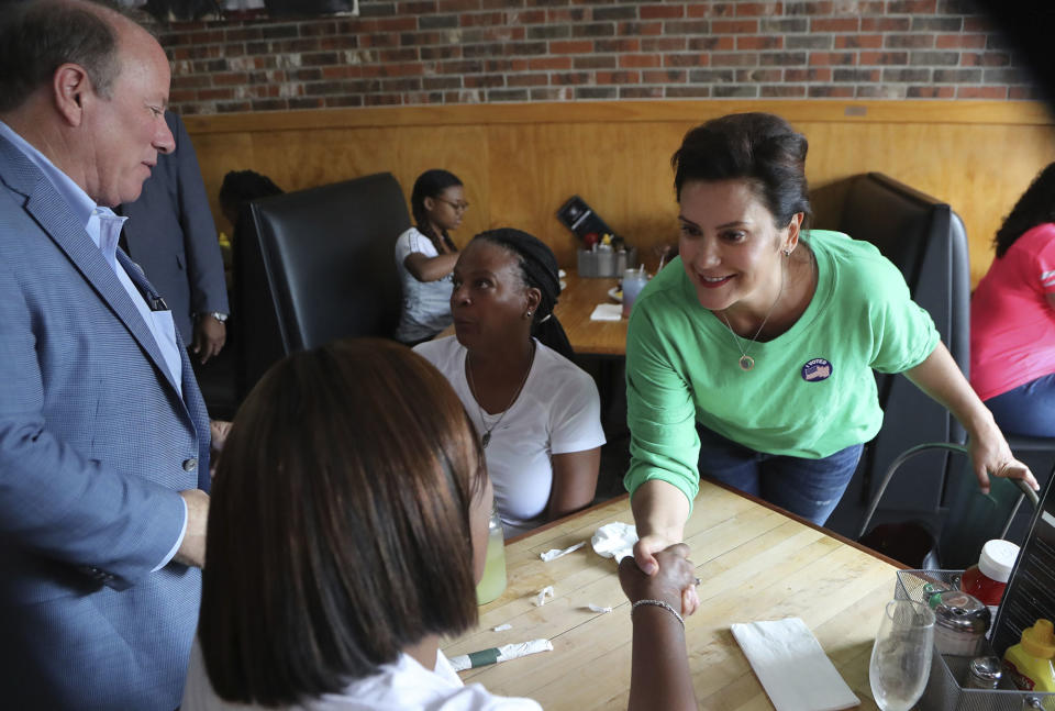 In August 2018, Whitmer campaigns at a Detroit restaurant with Mayor Mike Duggan (left).