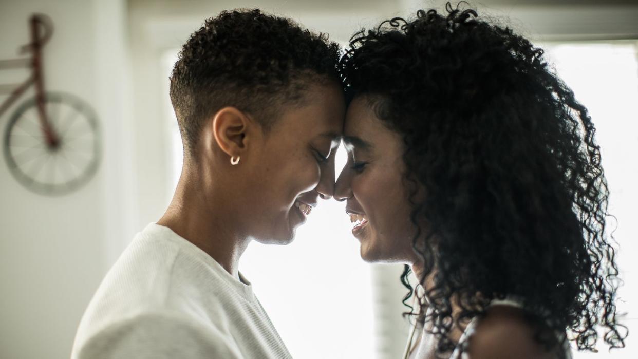 lesbian couple embracing at home