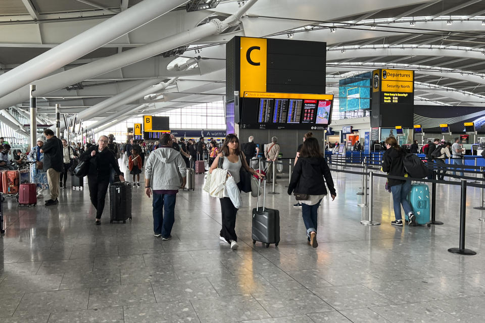 Passengers walk past the departures board at Heathrow Airport, in London, Monday, Aug. 28, 2023. Britain’s air traffic control system says it is experiencing a “technical issue” that could delay flights on Monday, the end of a holiday weekend and a busy day for air travel. (AP Photo/Alberto Pezzali)