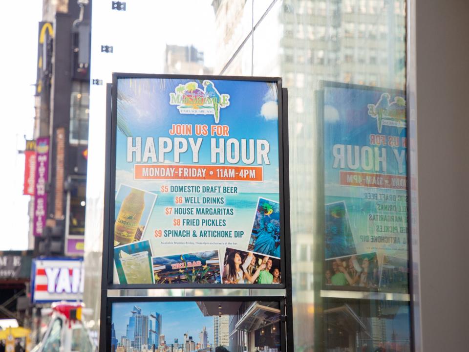 a sign outside the hotel noting the rooftop Happy Hour