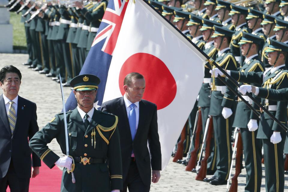 Australian Prime Minister Tony Abbott, center, reviews an honor guard during a welcome ceremony with Japanese Prime Minister Shinzo Abe, left, at Akasaka State Guest House in Tokyo Monday, April 7, 2014. Abbott is on a four-day official visit. (AP Photo/Koji Sasahara)