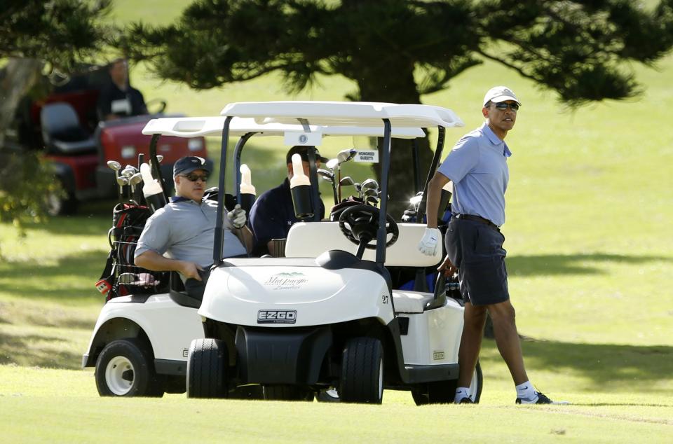 U.S. President Barack Obama (R) steps from his golf cart on the 18th hole during a round of golf at Mid Pacific Country Club in Kailua, Hawaii December 23, 2013. With Obama is his close friend Eric Whitaker (L). REUTERS/Kevin Lamarque (UNITED STATES - Tags: POLITICS SPORT GOLF)